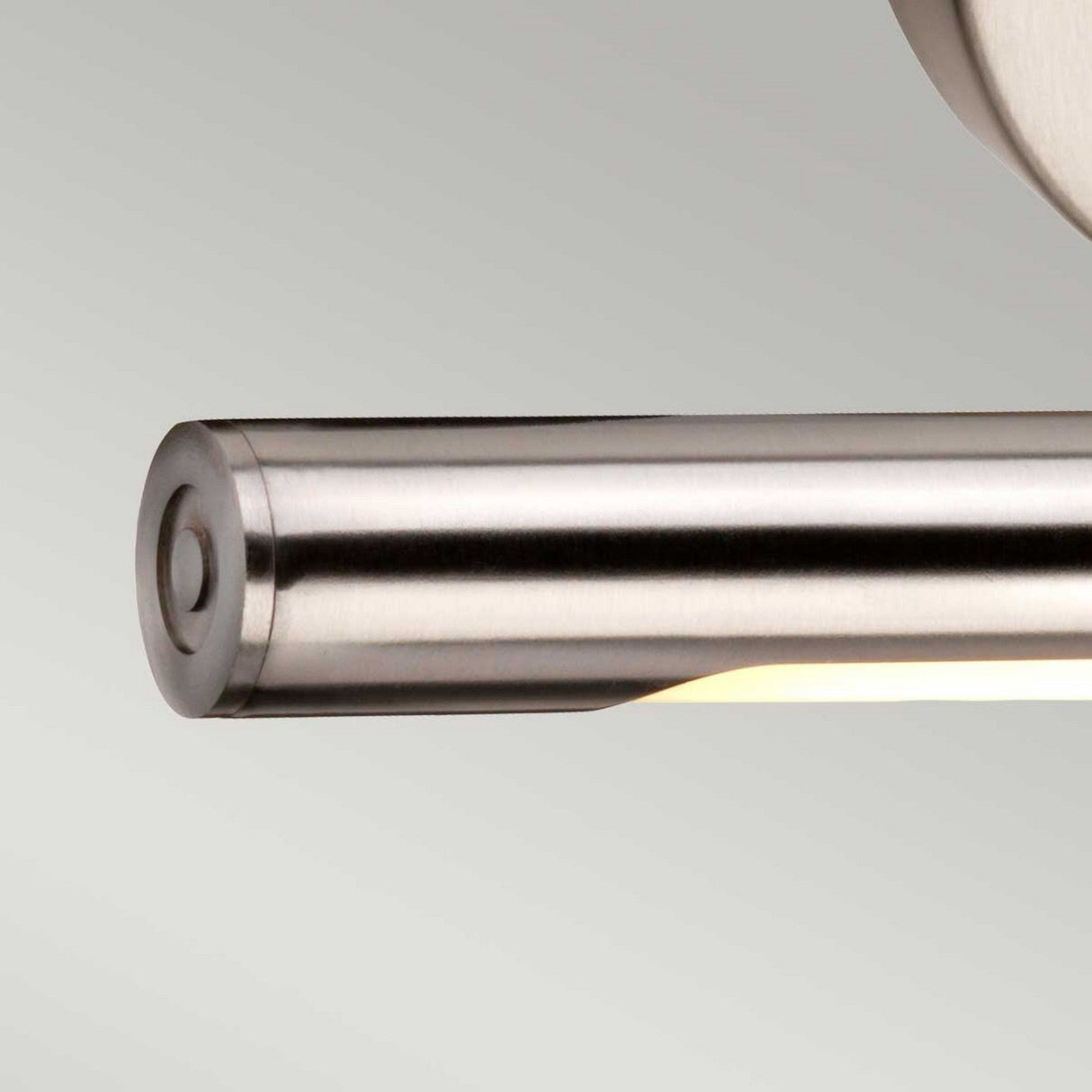 Close-up of the Alton 1 Light Small LED Picture Light in brushed nickel, featuring a sleek, modern cylindrical design with a warm glow. This fixture provides soft illumination against a neutral background, making it perfect for elegantly highlighting art.