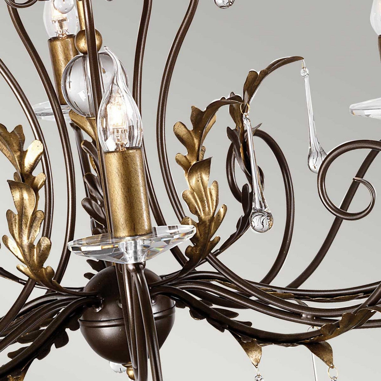 Close-up of the Amarilli 15 Light Chandelier, showcasing bronze metal leaves with a gold patina, delicate crystal accents, and candle-shaped light bulbs, all contributing to its elegant and sophisticated design.