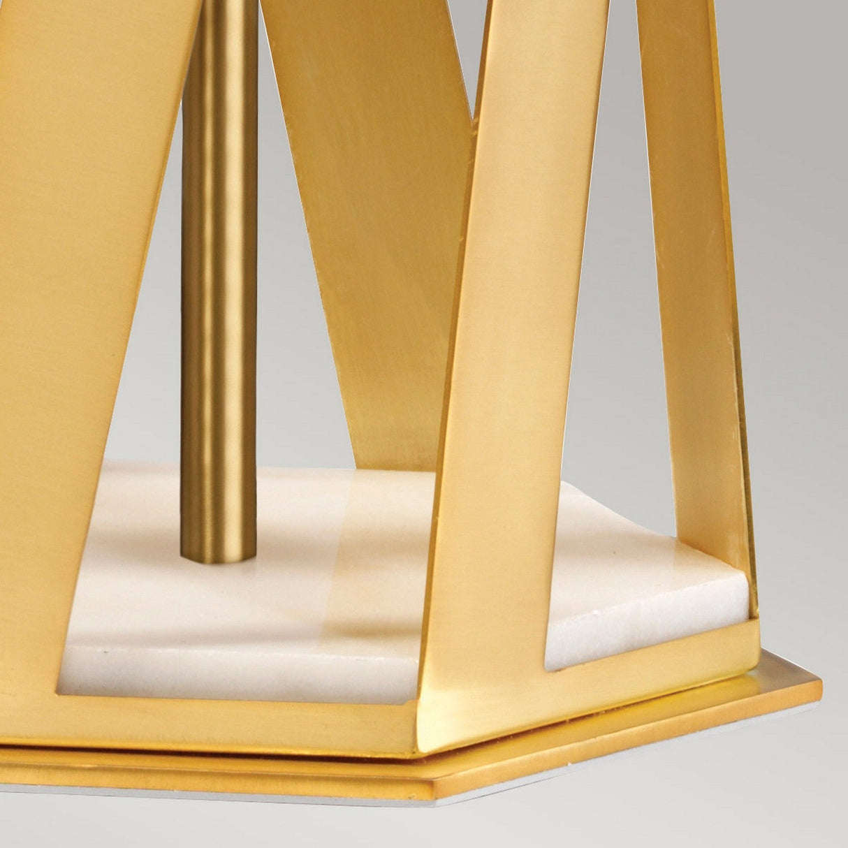 Close-up of the Apollo Table Lamp With White Shade - Brushed Brass, showcasing its marble base and angular intersecting metal structure. The vertical support enhances its modern and elegant aesthetic.