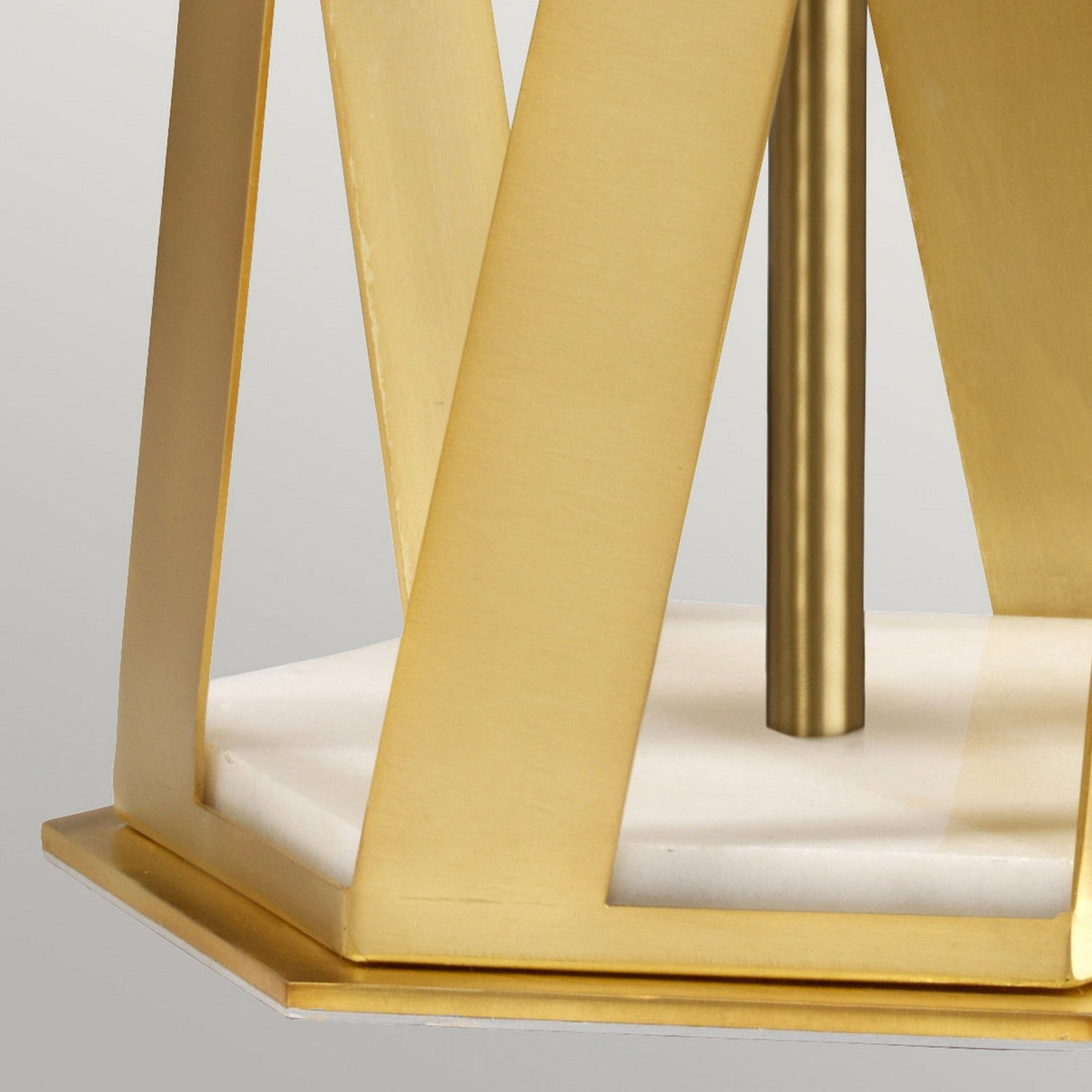 Close-up of the Apollo Table Lamp With Blue Shade - Brushed Brass, showcasing its geometric design. It has a brushed brass frame and rests on a hexagonal white marble base, topped with a blue shade for a minimalist and elegant appearance.