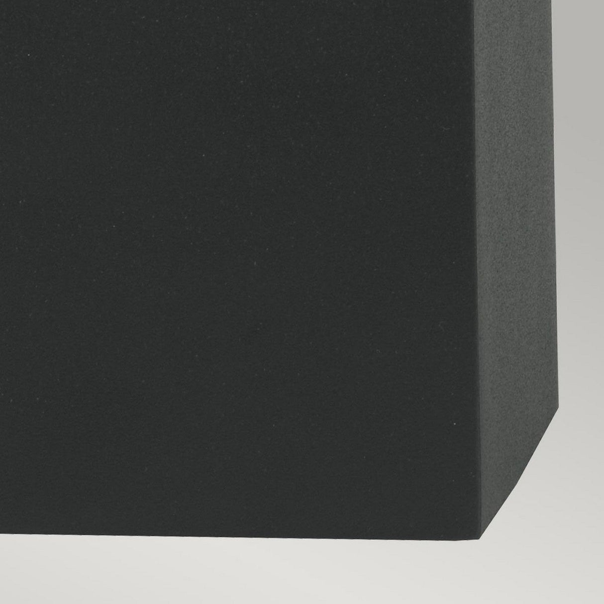 Close-up of the Arendal Outdoor 1 Light Wall Light in black, showcasing its rectangular design with a smooth, matte surface and sharp edges. It features a black powder-coated finish and is set against a light gray background. This product is built for durability in various conditions, boasting an IP65 rating.