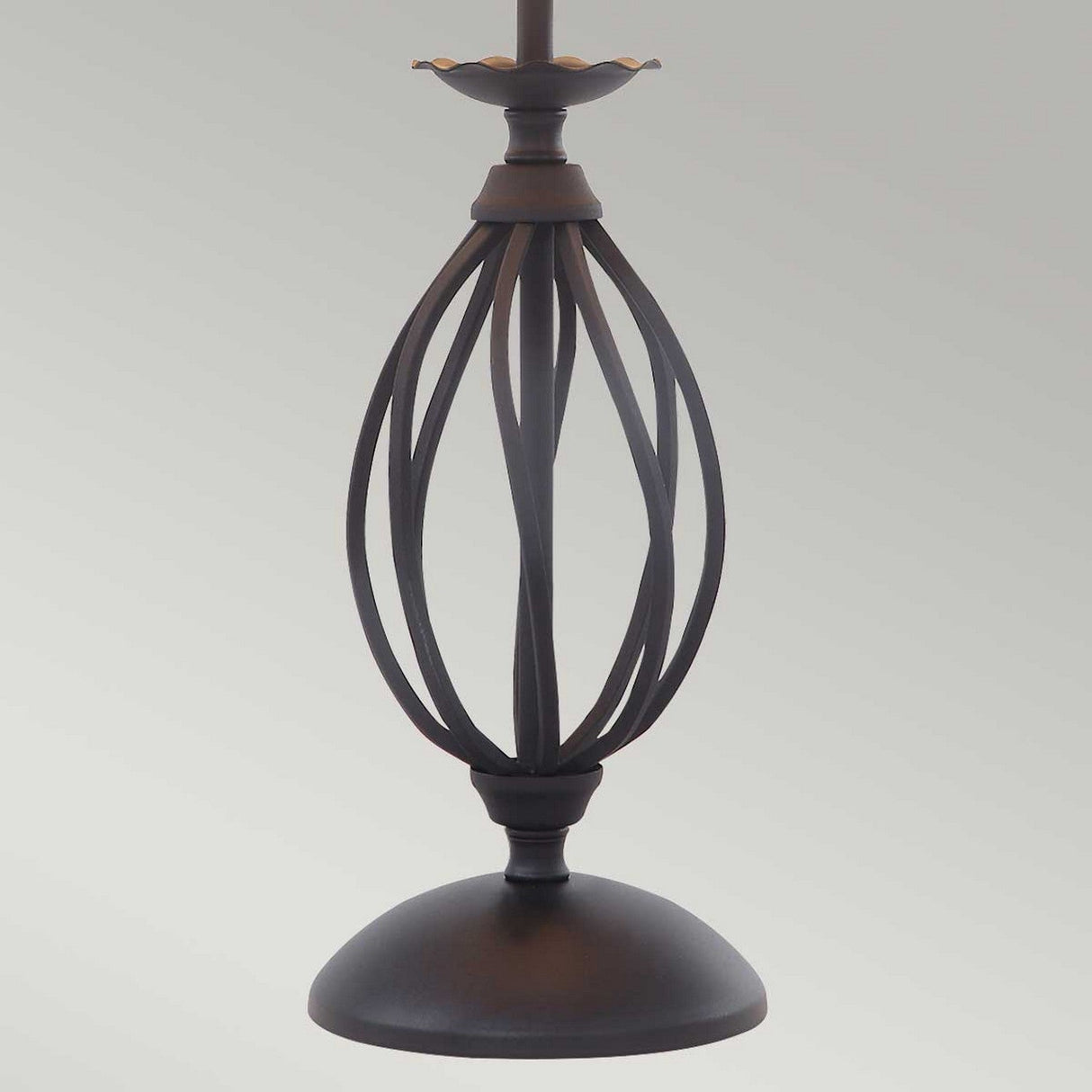 The Artisan Table Lamp - Black highlights a decorative metal base with its elegant black finish. The hand-formed metal scrolls create a striking open, curved design. Its round base and floral-like top detail stand out beautifully against a plain background.