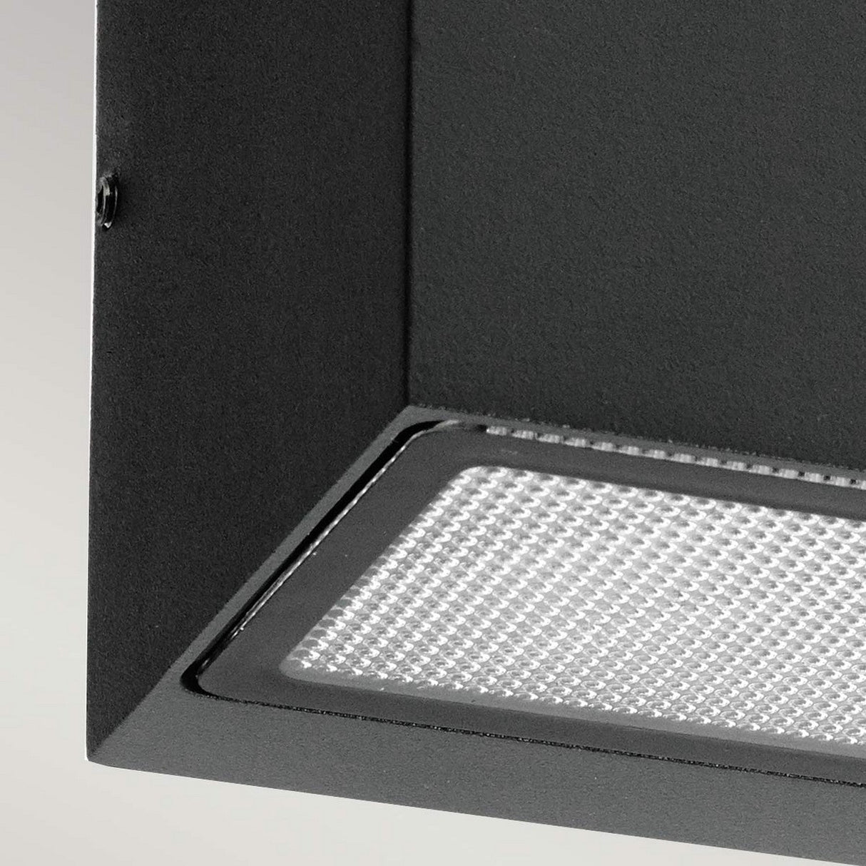 Close-up of the Asker Outdoor 1 Light Up/Down in a sleek graphite finish, featuring a smooth and angular design. Its IP65 rating for durability and style is reminiscent of a modern black ceiling range hood with a visible light mesh filter, suggesting it would suit both contemporary kitchen environments and outdoor settings.