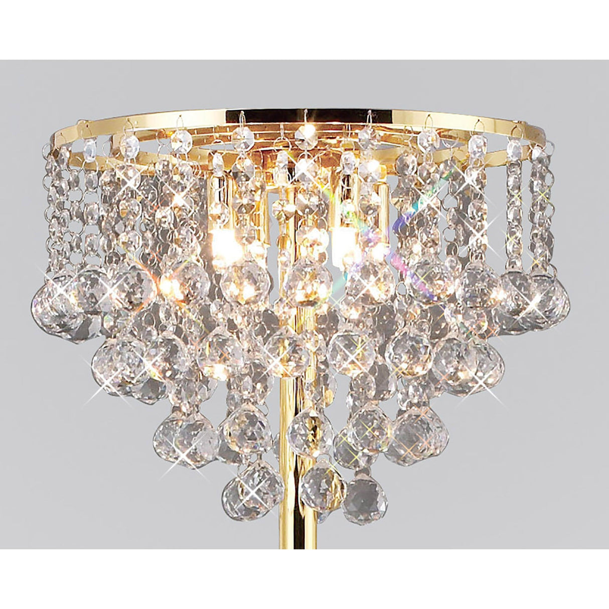 The Atla 4 Light Crystal Floor Lamp in French Gold features multiple tiers of hanging crystals, reflecting light beautifully to create sparkling effects against a plain background.