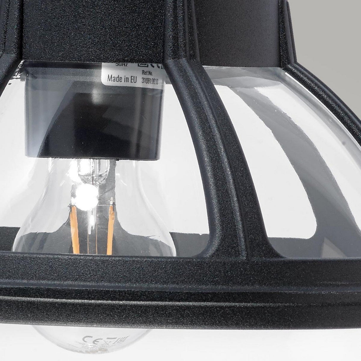 Close-up of the Bologna Outdoor 1 Light Down Wall Light in black, showcasing a globe-shaped lamp with a black metal and glass pendant light fixture featuring a clear bulb inside. Ideal for outdoor spaces, its IP54 rating ensures durability and protection against the elements.