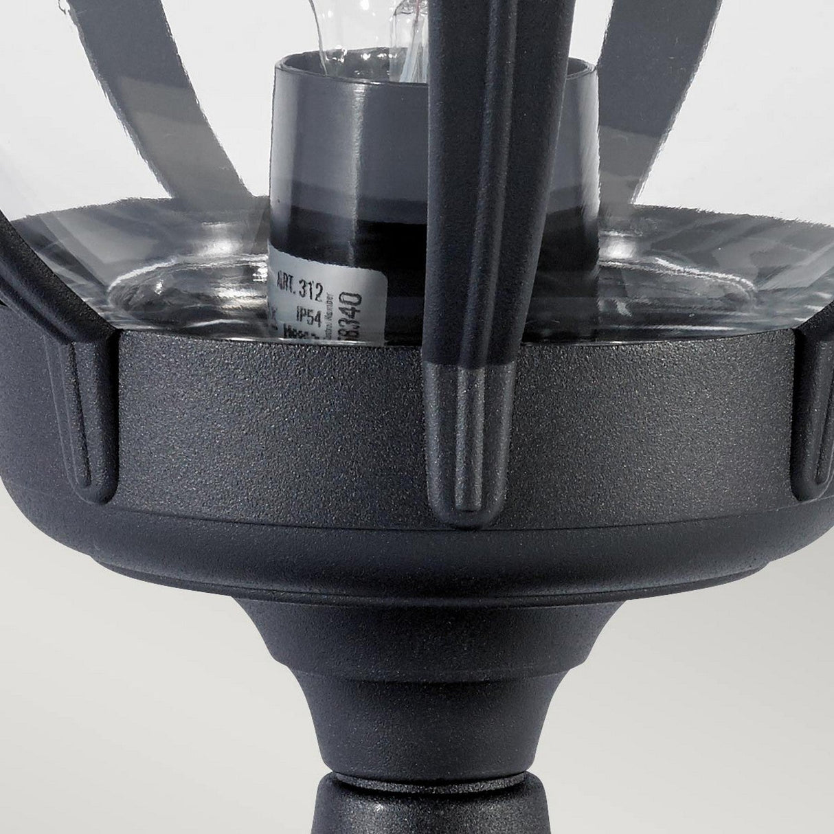 Close-up of the Bologna 1 Light Pedestal in black, featuring a clear glass cover that reveals the bulb inside and highlights its sturdy metal framework.