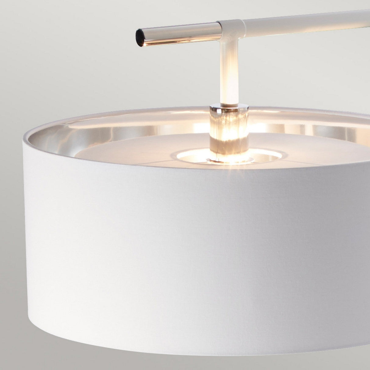 Close-up of the Balance Floor Lamp - White/Polished Nickel, showcasing its sleek metallic arm and white cylindrical shade. The gentle illumination casts a warm ambiance against a neutral backdrop, embodying the elegance of this polished nickel floor lamp.