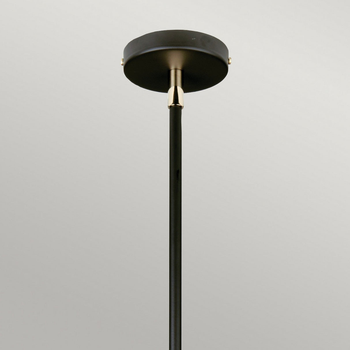 A close-up view of the Balance Pendant Light - Black/Polished Nickel attached to a round ceiling mount on a gray background. The black metal pole includes a small, gold-colored accent piece near the top, enhancing the contrast with its polished nickel finish.