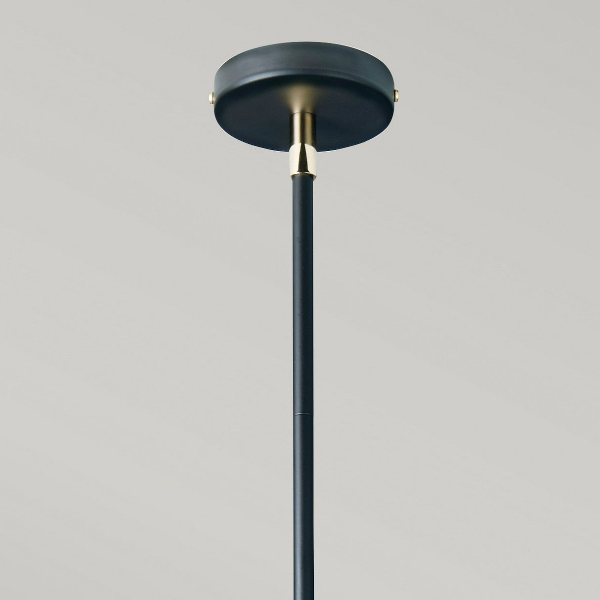 The Balance 5 Light Chandelier in Black and Polished Nickel is depicted against a neutral background. This minimalist fixture features a round ceiling mount and slender rod, with subtle polished nickel accents where the rod connects to the mount, reminiscent of a modern chandelier design.