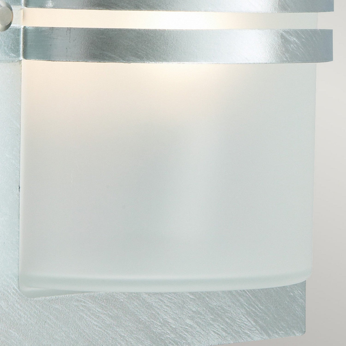 Here's a revised version of the sentence using the given product data:
Presenting a close-up of the Basel Outdoor 1 Light Wall Lantern in silver, showcasing its modern design. It features a frosted glass shade accented with metallic bands, softly glowing from within. The light achieves an IP54 rating for weather resistance while maintaining its sleek and contemporary look.