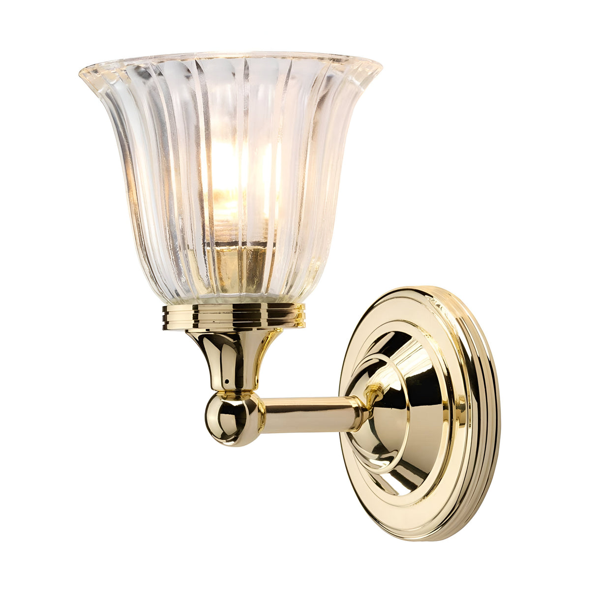 The Austen Wall Light in polished brass boasts a classic and elegant design, featuring a fluted glass shade that emits a warm glow. Its round base showcases clean lines and a reflective finish.