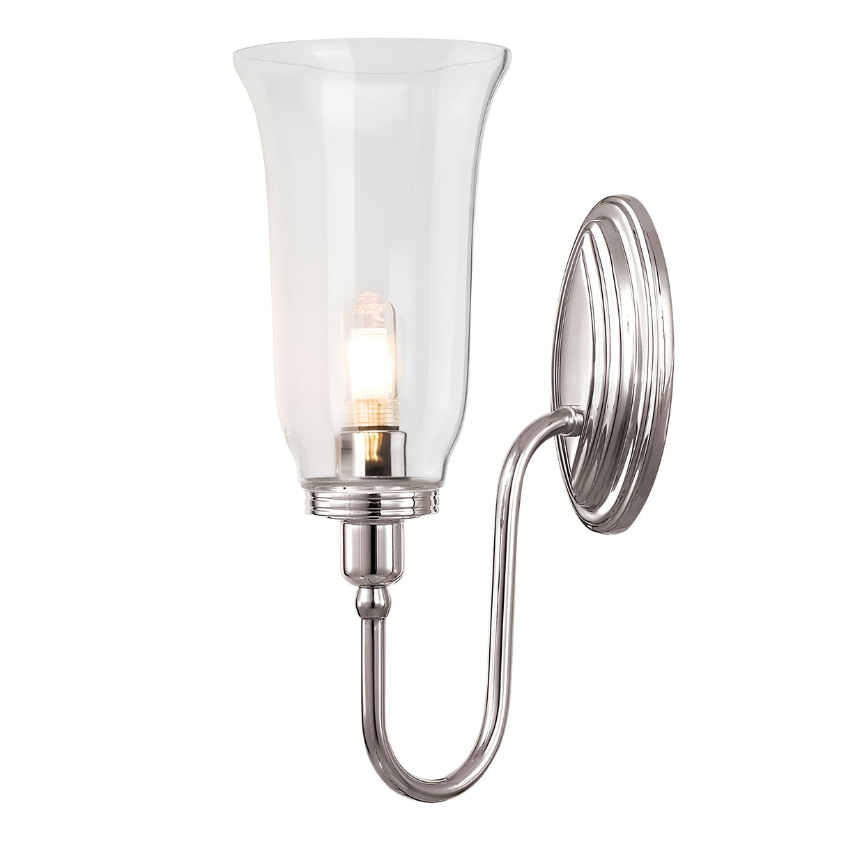 The Blake Wall Light - Polished Nickel showcases a sleek polished nickel base and a gracefully curved arm supporting a clear, flared glass shade. Inside, it houses a light bulb that emits a warm glow, enhancing the modern aesthetic of this wall-mounted sconce.
