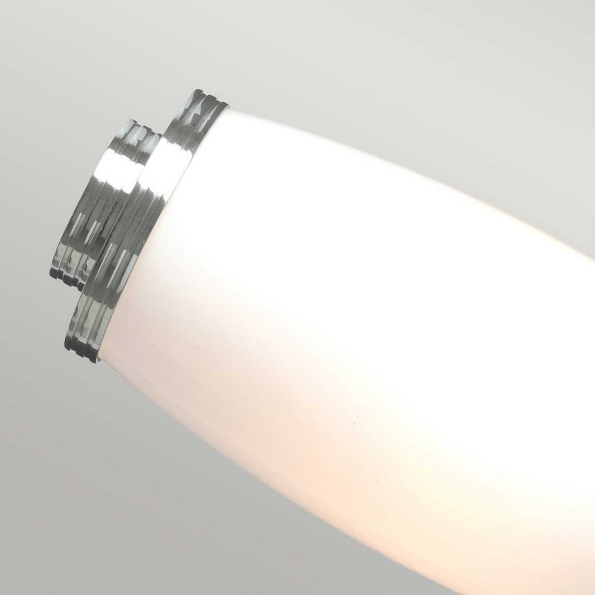 Close-up image of the Eliot 2 Light Wall Light in polished chrome, featuring a modern cylindrical design ideal for bathroom lighting. The energy-saving LED lamps provide a soft, diffuse glow against a neutral background.