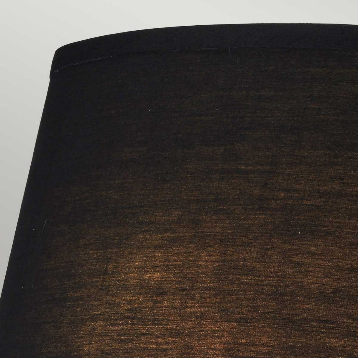 Detailed view of the black shade on the Falmouth Wall Light - Polished Chrome/Black Shade, with light streaming through to reveal its fabric texture. The warm illumination beautifully contrasts with the dark shade, enhanced by polished chrome details.