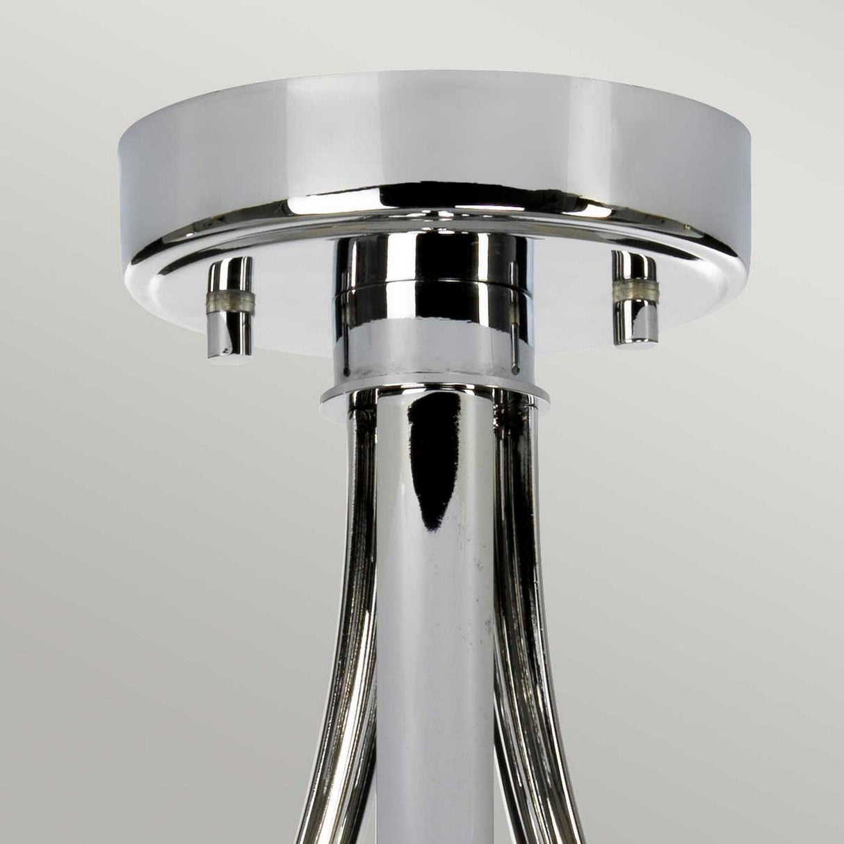 Close-up of a metallic ceiling fixture with a round base, featuring sleek, curved rods extending downward. The Falmouth 3 Light Semi Flush boasts polished chrome and a black shade, reflecting light and creating a sleek, modern aesthetic against a plain background.