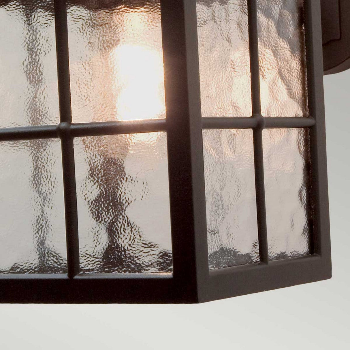 Close-up of the Winchester-2 1 Light Outdoor Wall Down Light in black, showcasing its vintage charm with a die-cast aluminum frame and textured glass panels that emit a warm glow.
