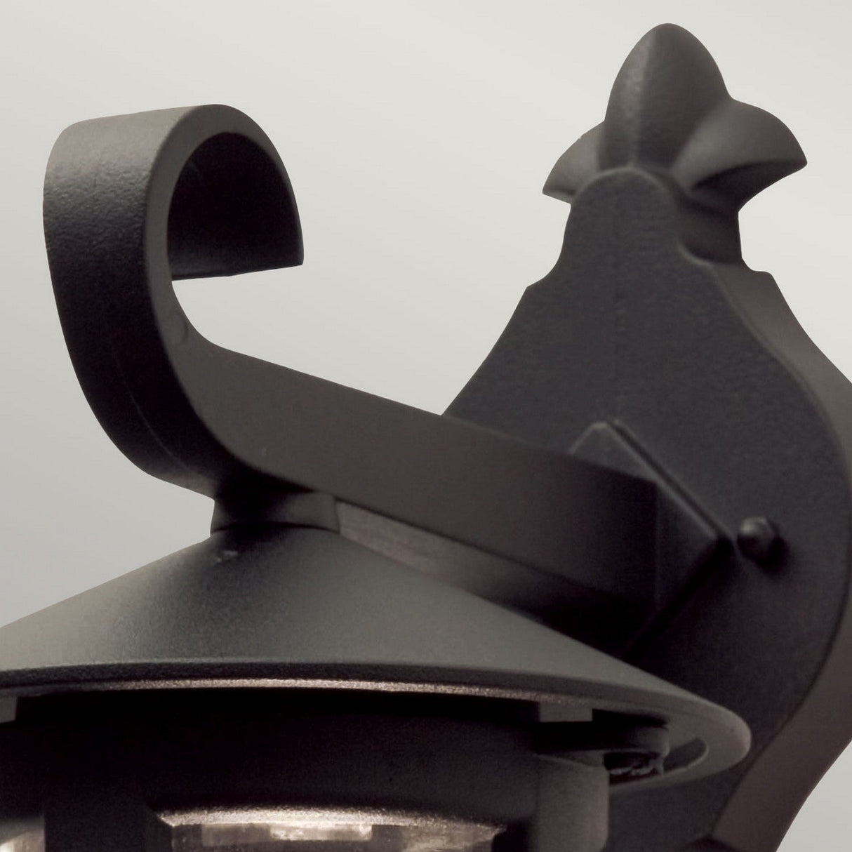 Close-up of the Hereford 1 Light Outdoor Wall Down Lantern in black, showcasing its lantern-style design with a decorative curved arm and pointed top detail. Crafted from die-cast aluminum, this large outdoor wall light stands out beautifully against a neutral background.