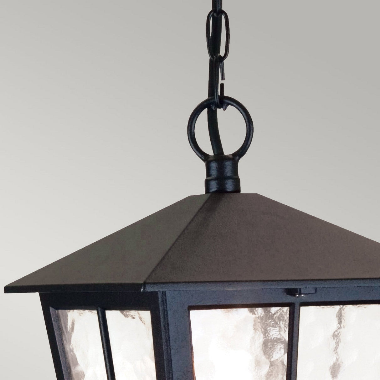 Here's a revised version of the sentence using the given product data:
Close-up of a Canterbury 1 Light Outdoor Chain Pendant - Black—a black, metal hanging lantern with a chain and ring at the top, featuring glass panels that beautifully diffuse light. It is perfect for outdoor lighting and stands out against the soft gray background.
