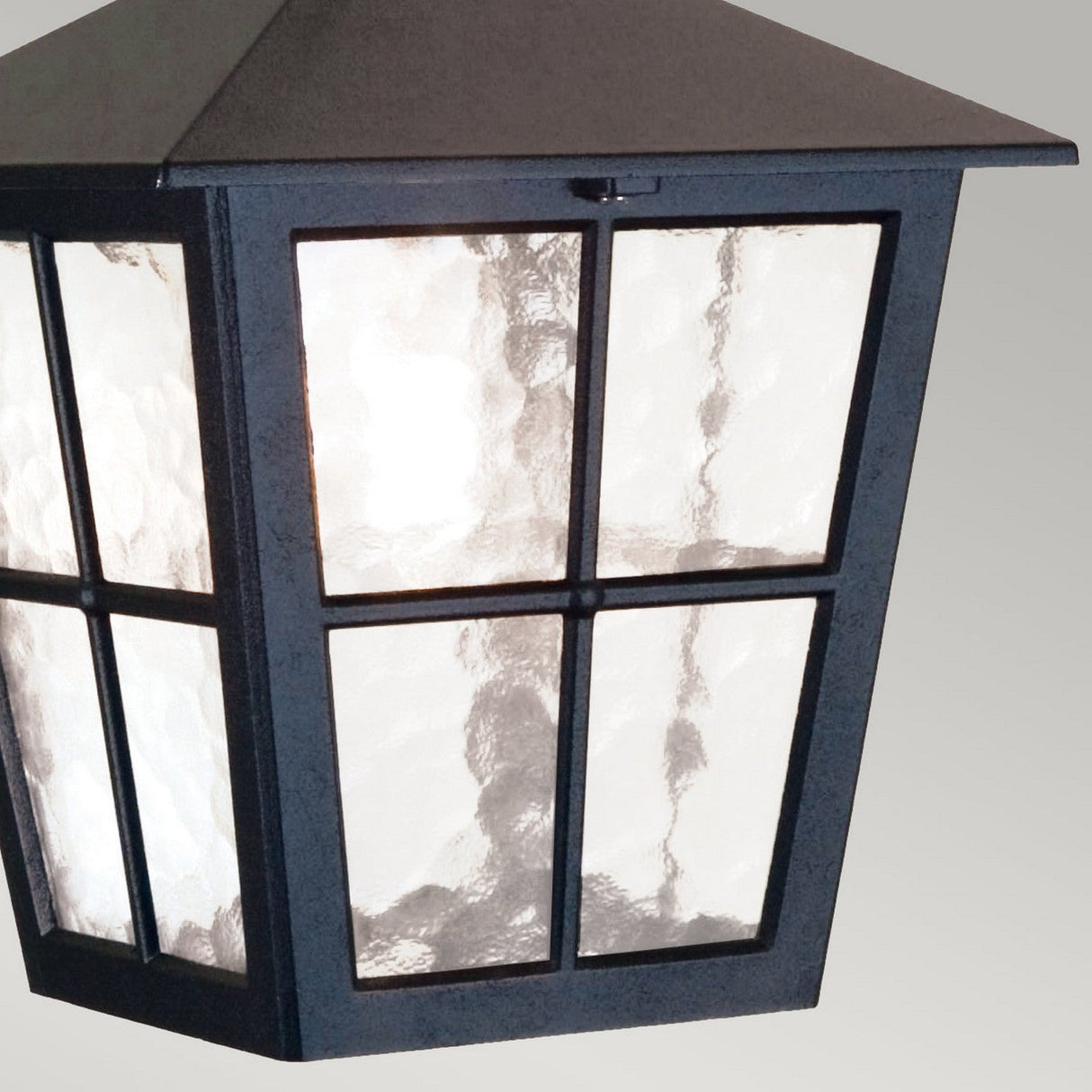 Close-up of the Canterbury 1 Light Outdoor Chain Pendant in black, featuring wavy glass panes against a light gray background. This outdoor lantern is crafted to house a light bulb inside, casting a beautiful glow through its patterned glass.
