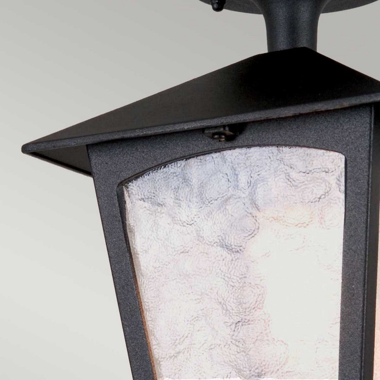 A close-up view of the York 1 Light Outdoor Ceiling Light in black, featuring a vintage aesthetic and crafted from durable die-cast aluminum. This elegant lantern showcases frosted glass panels and a textured surface, designed to provide a soft, diffused glow when mounted outdoors.