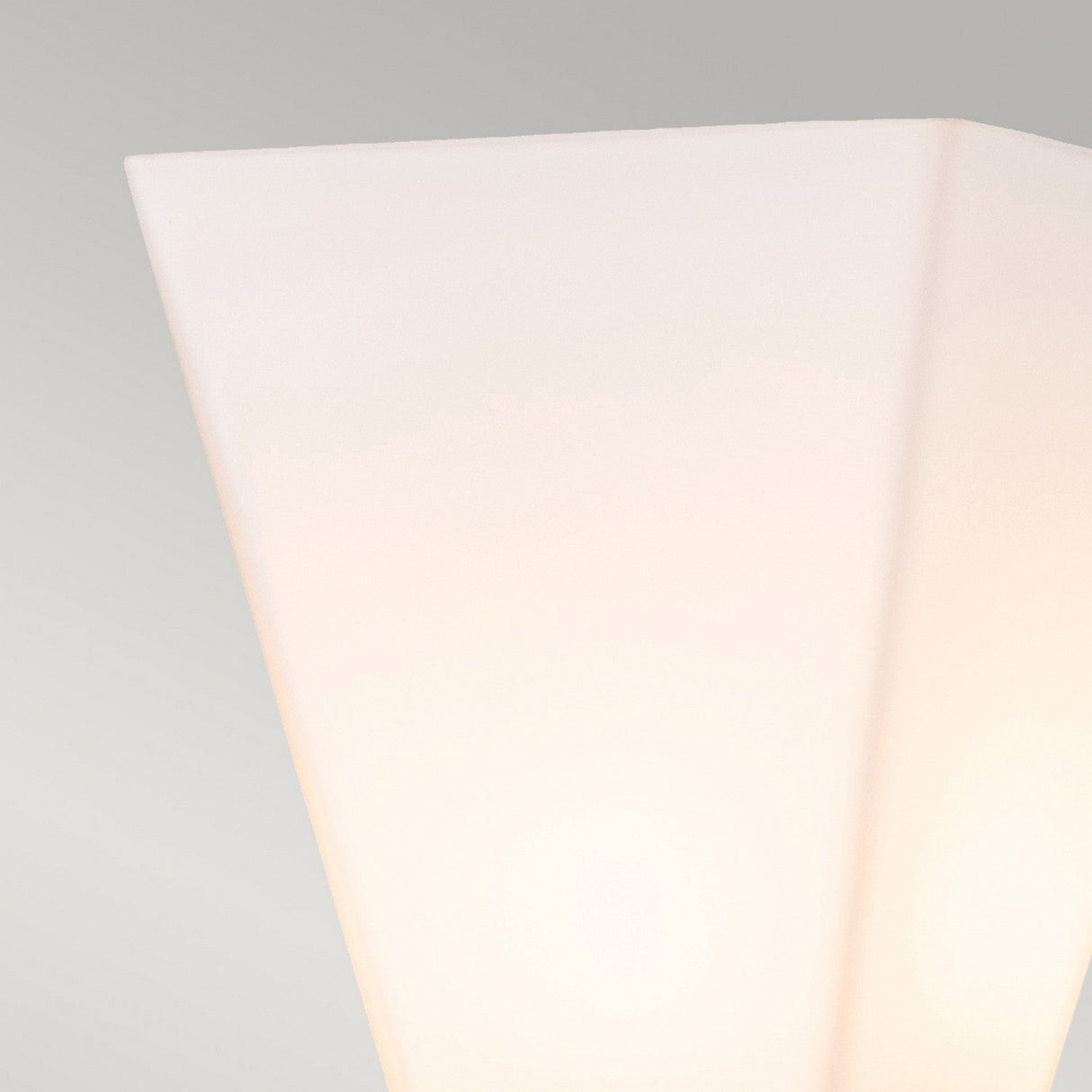 Close-up of the Bowtie 1 Light Wall Light in matte black featuring a soft, diffused glow against a plain gray backdrop, ideal for sleek bathroom lighting.