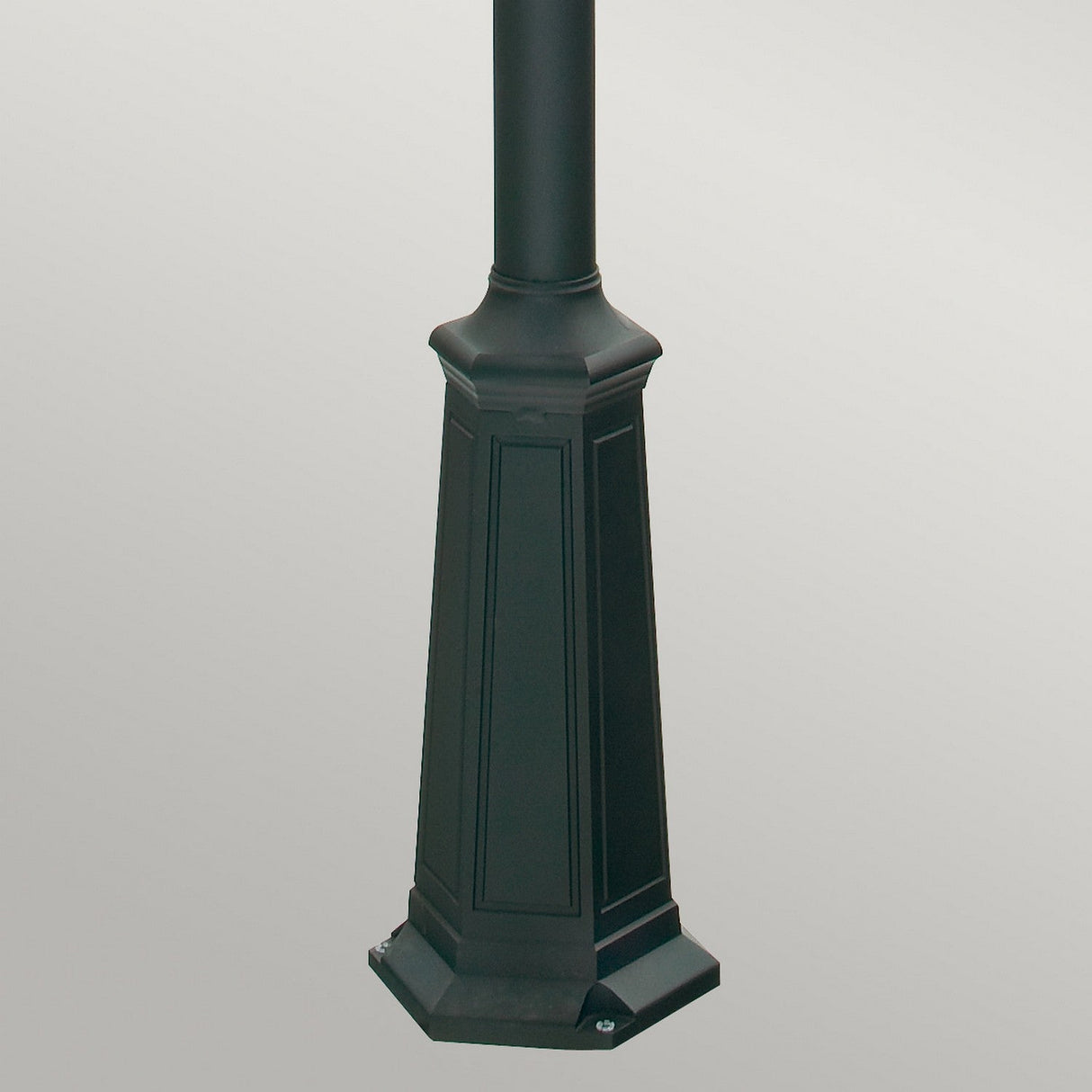 A close-up of the Como 3 Light Triple Head Post - Black reveals its hexagonal base and decorative paneling, ideal for outdoor lighting. The background is a plain light gray. Upgrade your space with the IP54 rated durability of this elegant street lamp design.
