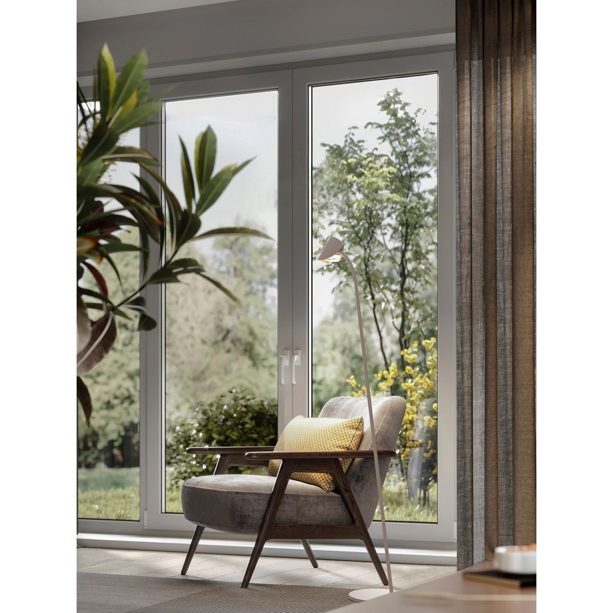 A modern armchair with a yellow cushion sits by large glass doors, overlooking a lush garden. The Capuccina LED Floor Lamp 8.5W 3000K - White provides ambient lighting as natural light fills the cozy, stylish room.