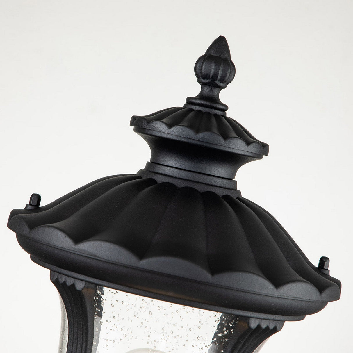Image of the Chicago Small Pedestal Lantern - Black, showcasing its ornate vintage design with a decorative finial and curved detailing. The lantern's glass displays subtle water spots against a plain light background, ideal for elegant garden lighting.