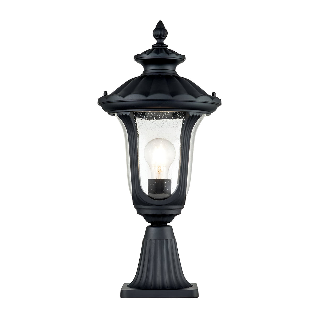 The Chicago Small Pedestal Lantern - Black is designed with a vintage touch, showcasing a clear glass enclosure and a visible light bulb inside. Featuring a decorative top and a fluted base, this black outdoor lantern is perfect for garden lighting or adding charm to your front door.