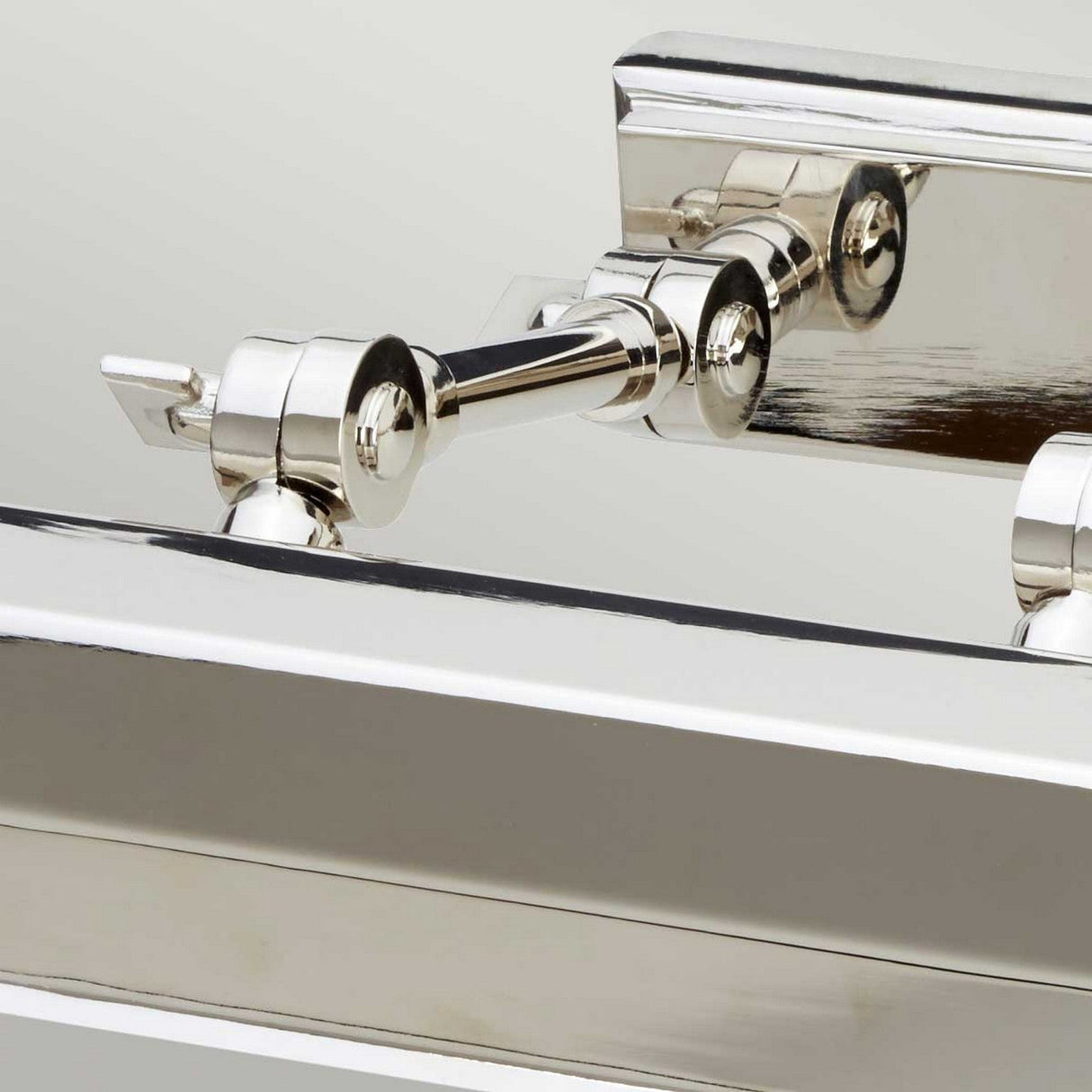 Close-up of the Chawton Medium Picture Light - Polished Nickel, showcasing its shiny, reflective surface and interconnected cylindrical components with adjustable knuckle joints against a plain background.