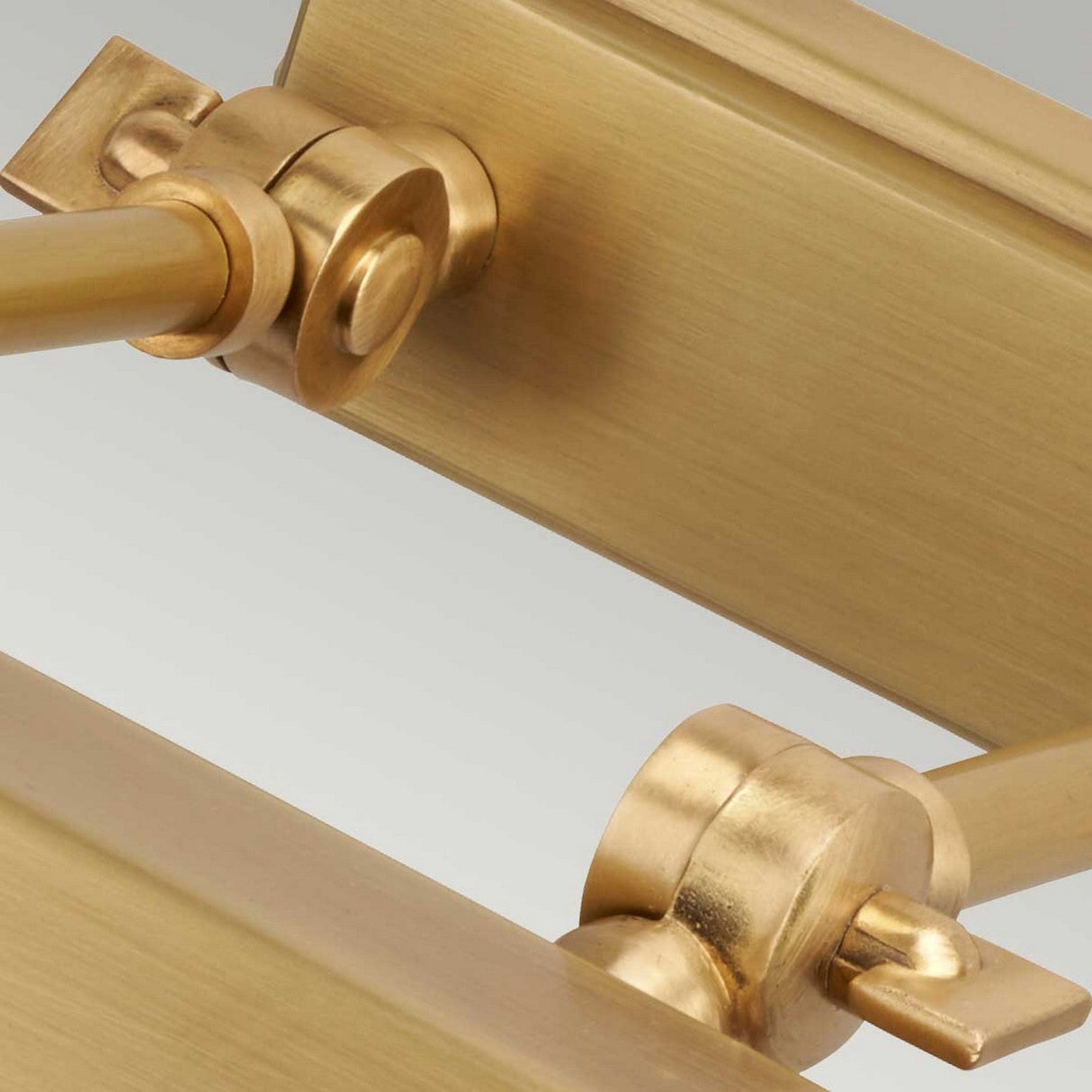 Close-up of the Chawton Small Picture Light - Aged Brass, highlighting its smooth texture and polished golden finish. The fixture includes two pivot points and a horizontal arm for precise directional lighting.