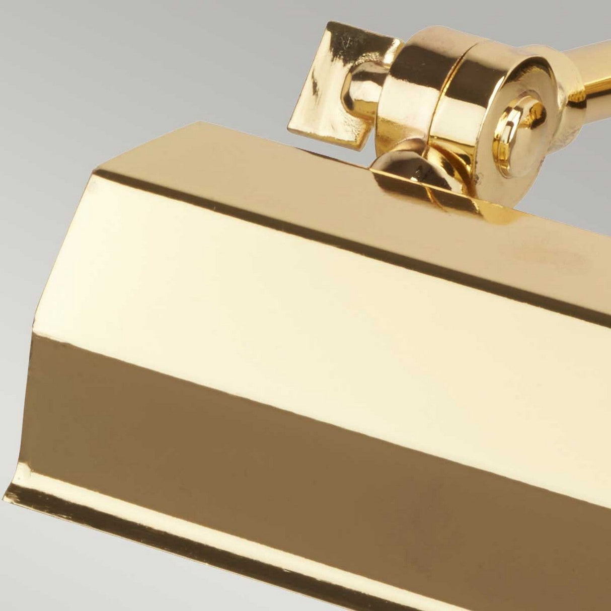 Close-up of the Chawton Small Picture Light - Polished Brass, highlighting its polished brass swing-arm and adjustable knuckle joints. The light's rectangular shade and hinge are set against a neutral gray background.