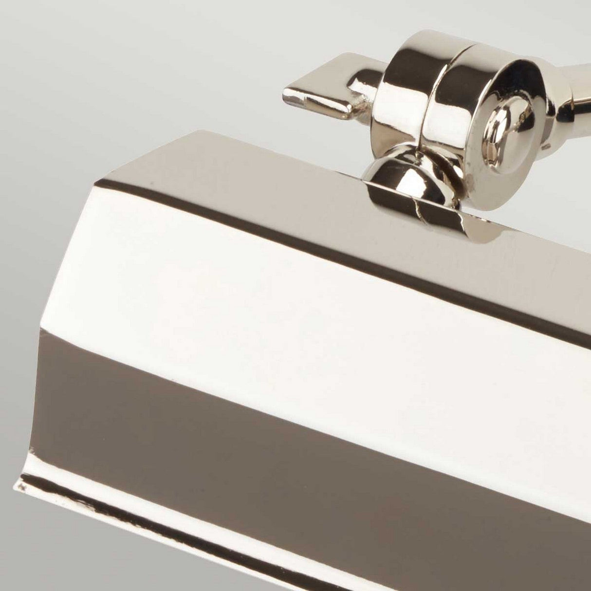 Close-up of a Chawton Small Picture Light - Polished Nickel, featuring a rectangular head and adjustable knuckle joints. This elegant picture light displays a polished nickel finish, reflecting light off its modern design against a neutral gray background.
