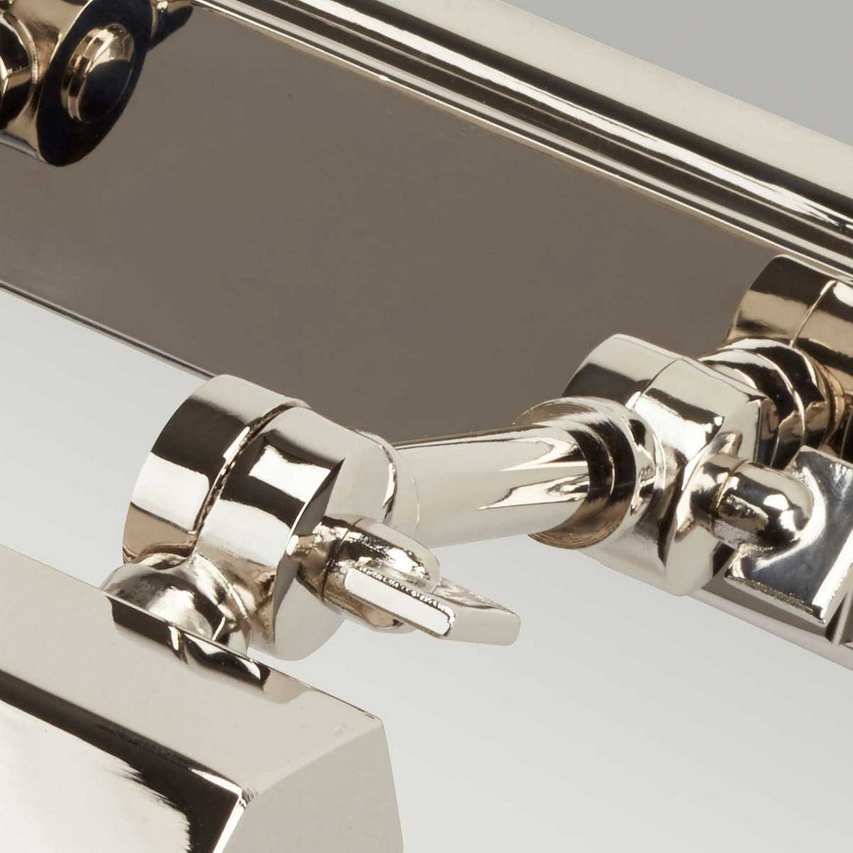 Close-up of the Chawton Small Picture Light - Polished Nickel, highlighting its polished nickel finish and adjustable knuckle joints that enhance its sleek metallic allure.