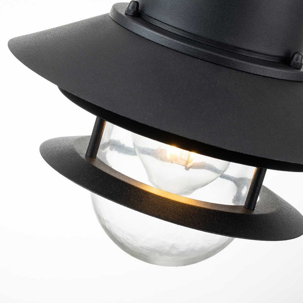 Introducing the Copenhagen Outdoor 1 Light Chain Pendant in Black, this modern fixture features a layered design that draws inspiration from Danish aesthetics. Its softly glowing bulb is beautifully encased within a clear glass dome, while overlapping shades contribute to its polished and contemporary appearance, making it an ideal choice for elegantly lighting up coastal areas.