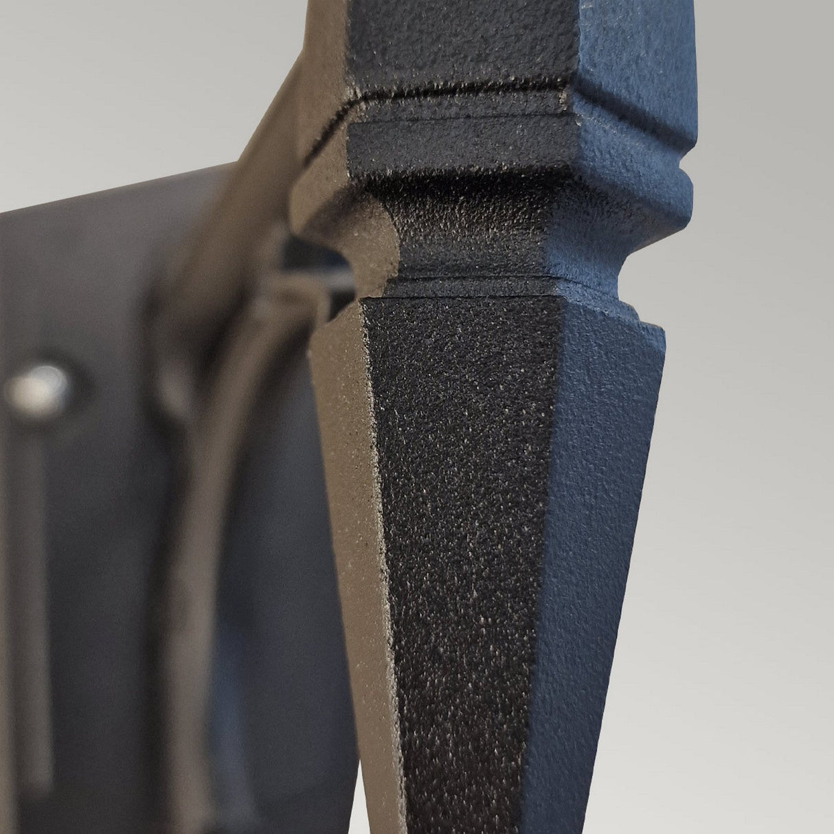 Close-up of the Chapel 1 Light Outdoor Up Wall Lantern in black, featuring a textured die-cast aluminum body with angular, geometric design elements set against a gradient gray background, suggesting its potential for outdoor lighting and robust IP44 rating.