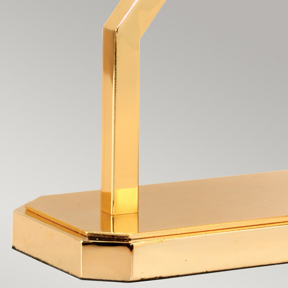 Zoomed-in view of the Cross Table Lamp with an Ivory Shade, highlighting its polished gold base and sleek, contemporary design. The base and arm boast clean, angular lines that enhance its modern appeal against a soft gray backdrop.