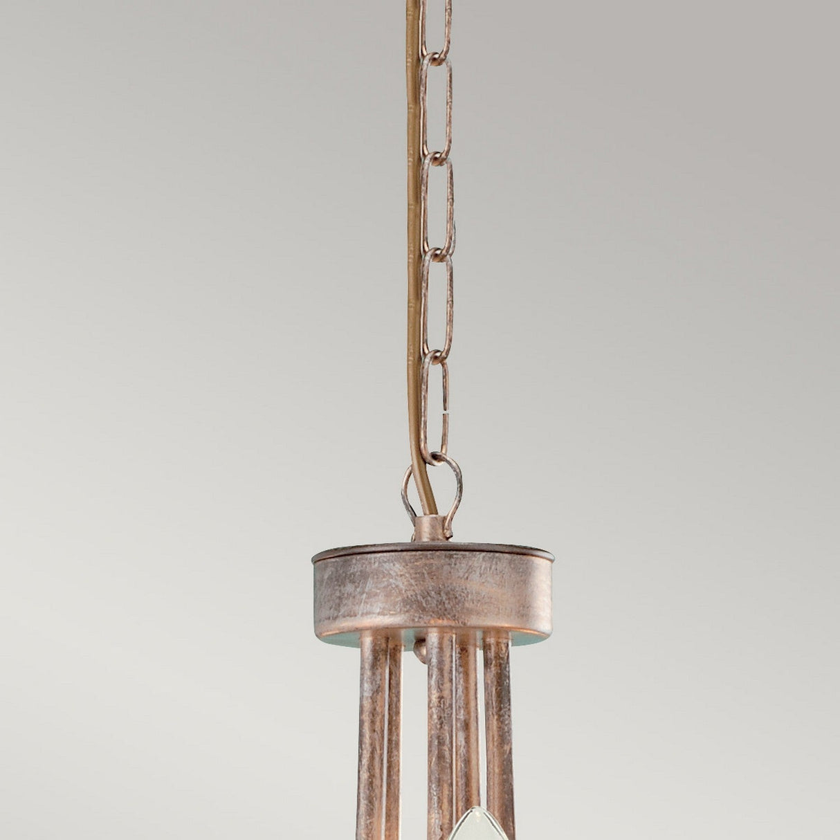 A close-up of the Christina 5 Light Chandelier - Silver/Gold Patina hanging from a chain against a neutral background. The fixture, with its chandelier-like design, features vertical rods and a weathered metallic finish, topped with a small round cap.
