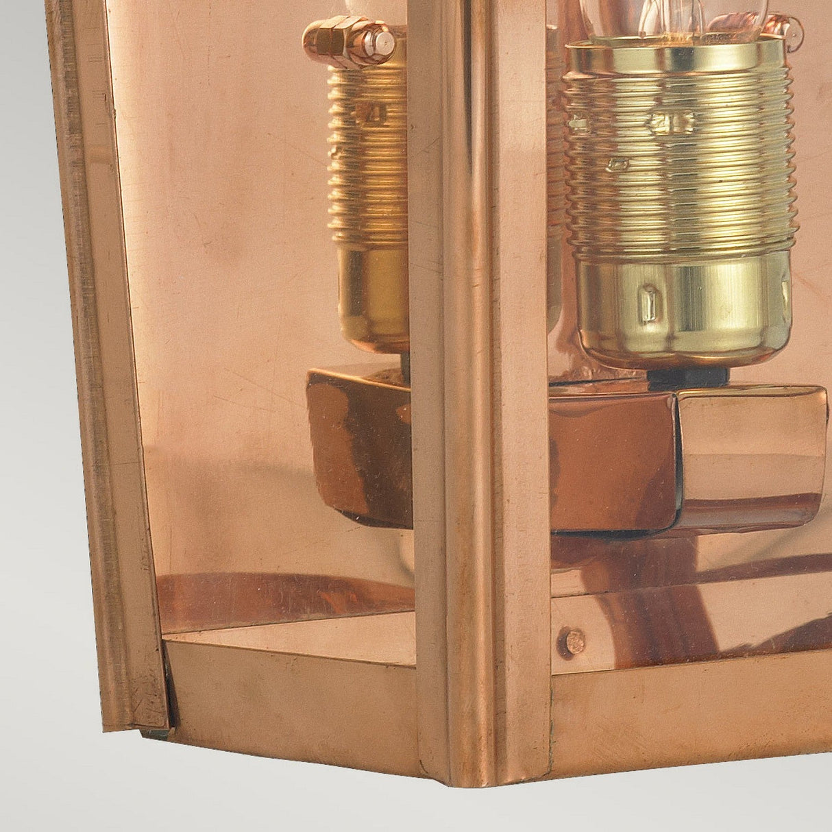 Capture a detailed view of the Chelsea Outdoor 1 Light Large Half Lantern in copper, showcasing its vintage appeal with exposed bulbs and brass sockets. The design incorporates reflective surfaces and metallic accents, emphasizing the intricate craftsmanship and rich warmth of the copper finish. Perfect for elevating outdoor lighting aesthetics.