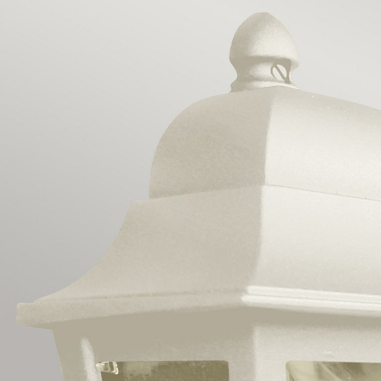 Close-up of the Deco Outdoor Wall Lantern in cream with a domed top, showcasing minimalistic features in a modern design. The plain, light gray background enhances the clean look and elegant finish of this piece.