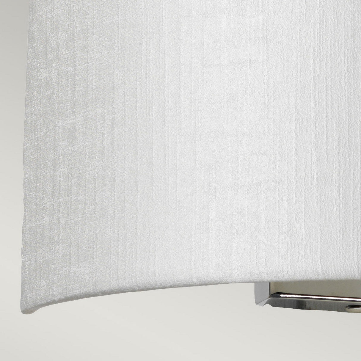 Close-up of the Cooper Medium Curved Wall Light featuring a white textured fabric shade and a polished chrome base, ideal for contemporary interiors, set against a light gray background.