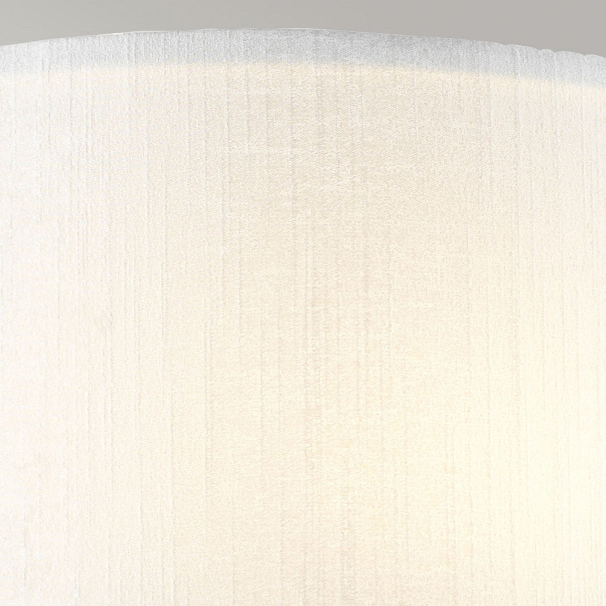 Close-up of the Cooper Medium Curved Wall Light in polished chrome emitting soft, warm light—a perfect fit for contemporary interiors. The smooth surface features vertical lines, adding a subtle pattern. The top edge of the fixture is slightly visible against a neutral background, enhancing modern elegance.
