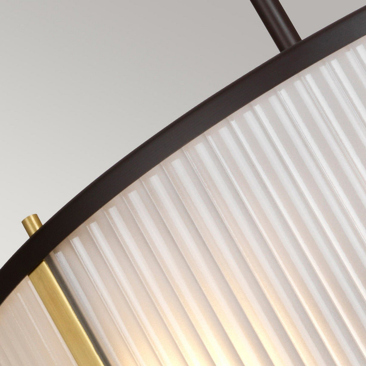 Close-up of the Corona 3 Light Pendant with a ribbed glass shade and bronze dark brown accents. The design showcases a blend of vertical and diagonal lines, offering an elegant and contemporary appearance.