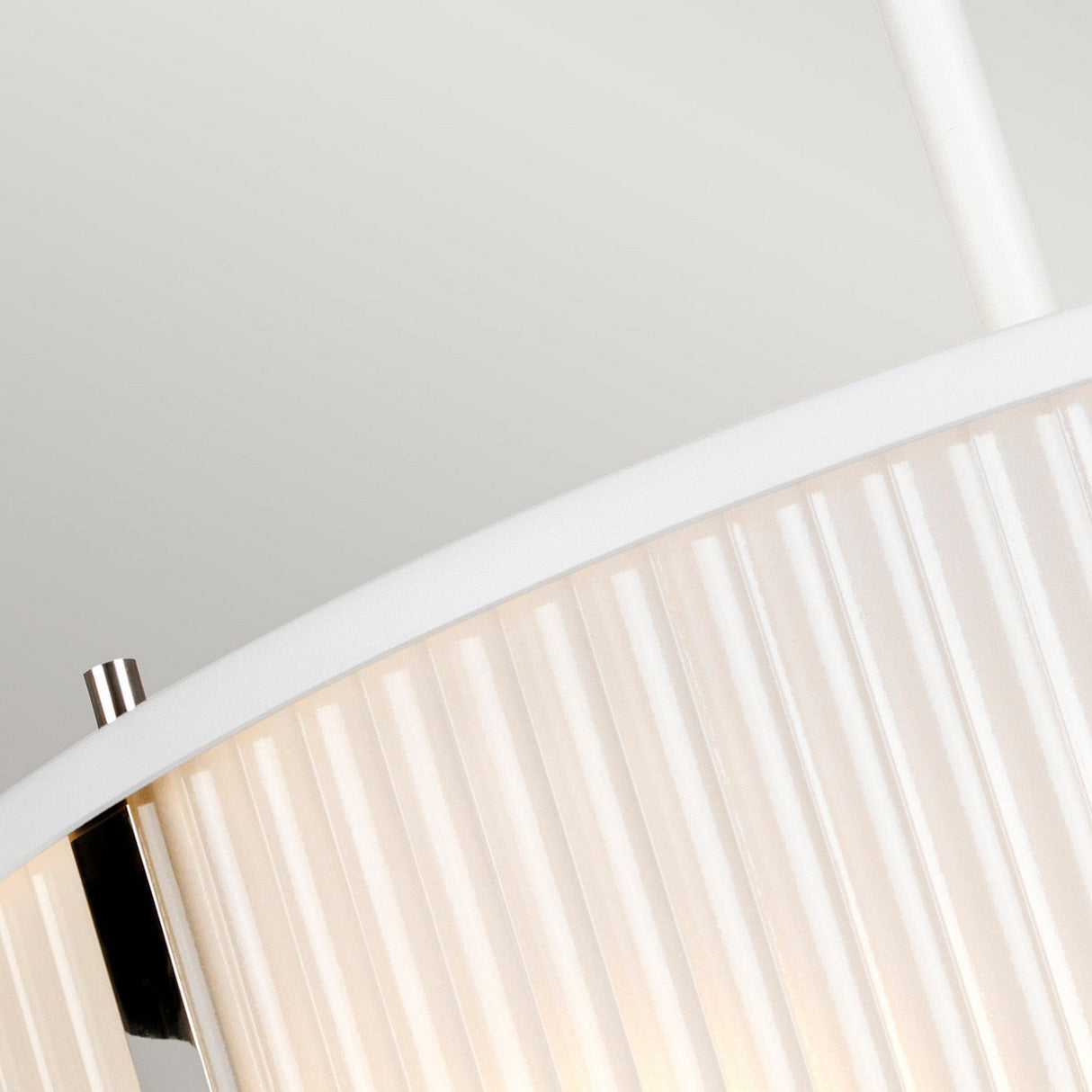Close-up of a versatile lighting fixture, the Corona 3 Light Pendant / Semi-Flush in White Satin features a ribbed lampshade accented with chrome. The image emphasizes the curved edge and texture against a plain background, capturing the elegance of this modern pendant.