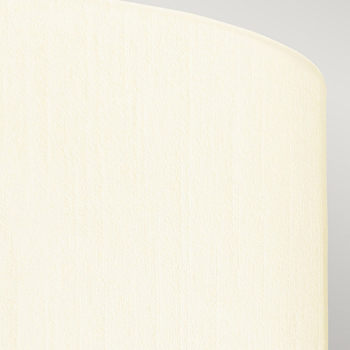 A close-up of the Fletcher 22" Flush with its polished chrome base and an ivory shade shows off a textured cream-colored surface with a rounded edge against a lighter gray background. The lighting, evocative of modern interior designs, highlights the texture, lending the surface a soft and subtle appearance.