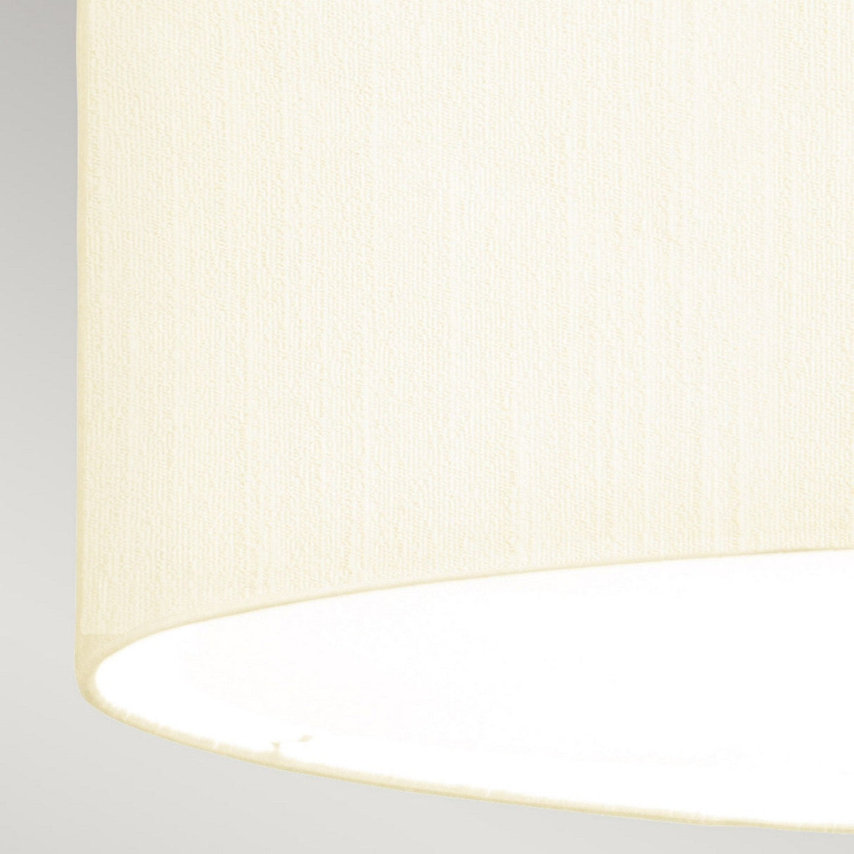A close-up of the Fletcher 22" Flush in polished chrome with an ivory shade on a light background, softly illuminated from within. The fabric texture is visible, adding warmth to the modern interior lighting complemented by sleek touches of polished chrome.