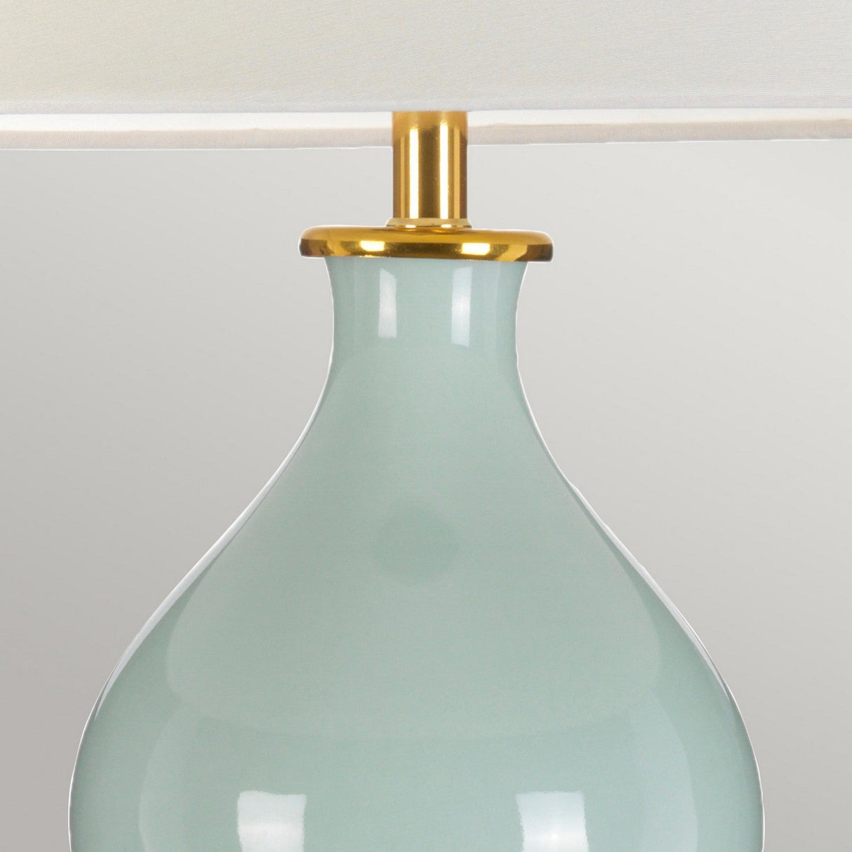 The Harbin Gourd Table Lamp with a Tall Empire Shade in celadon finish features a modern design with a curved base and gold accent at the neck, set against a neutral background.