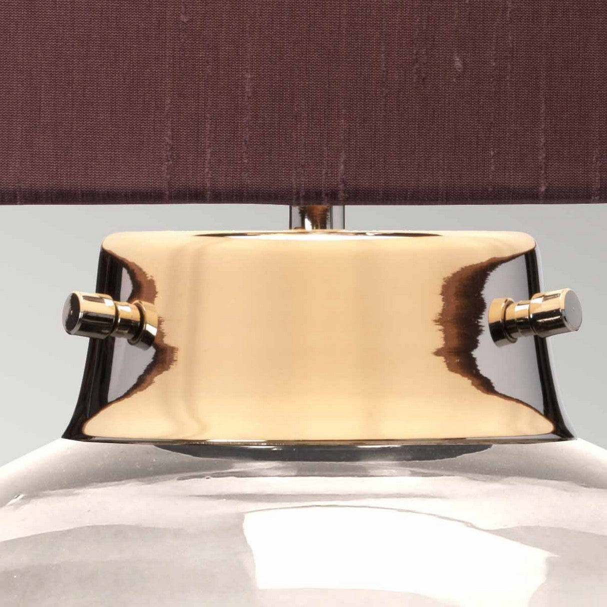 Close-up of the Kara Table Lamp, featuring a smoke glass base and a polished nickel neck. The dark, textured lampshade beautifully contrasts with the sleek design, accentuating the elegant reflective surface of this piece.