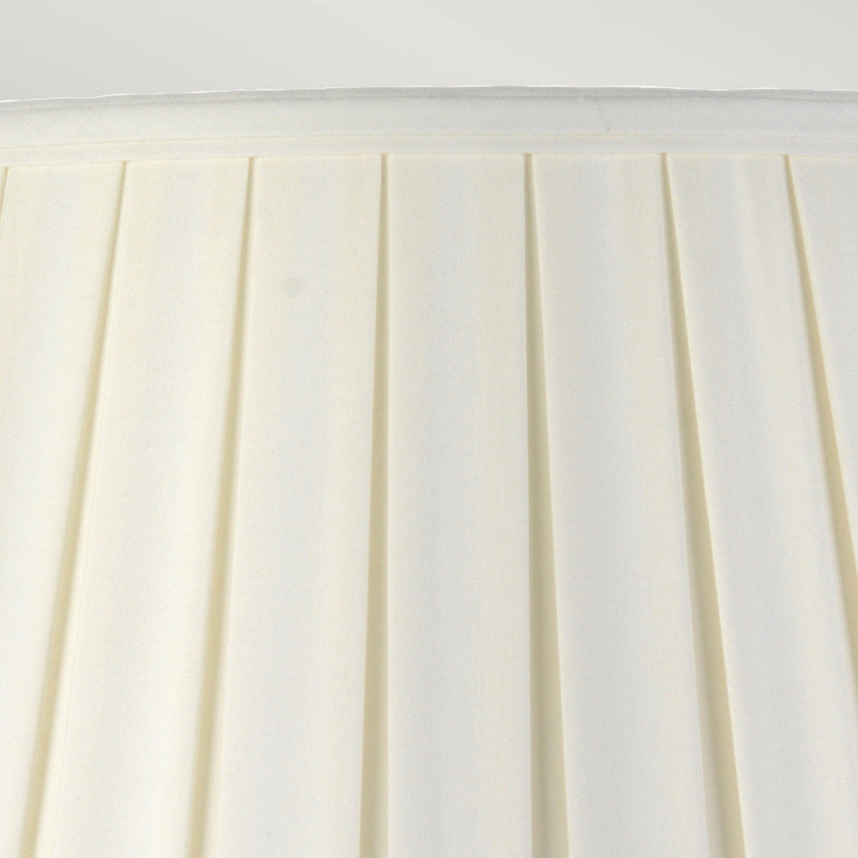 Close-up of the Linyi Table Lamp's tall empire shade, featuring off-white pleated fabric with a simple yet elegant design. The pleats add a subtle texture to the surface, giving the lampshade a classic look that beautifully complements its ceramic base and matches any blue and white lamp ensemble.