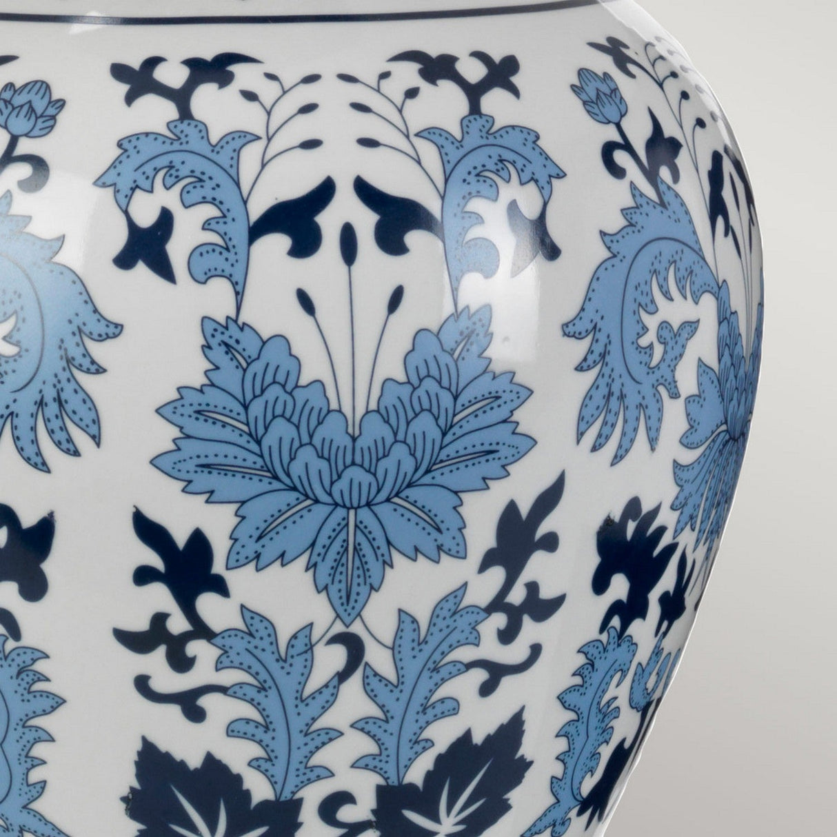 A detailed close-up of the Linyi Table Lamp With Tall Empire Shade in blue and white, showcasing its ceramic base adorned with intricate floral patterns. This design features stylized flowers and leaves on a white background, creating an elegant and traditional decorative effect that perfectly complements the lamp's tall empire shade.